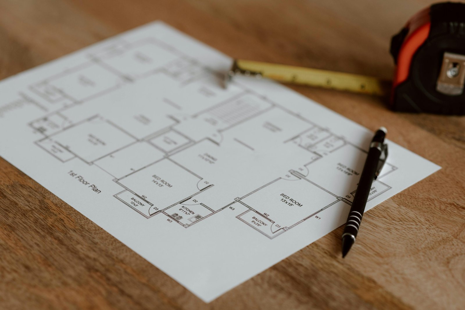 Architecture scheme of floor on paper placed on wooden surface near pen and ruler in room during renovation work in building